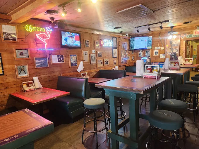 Booth seating area at Gatorz with Corona neon and Stella sign