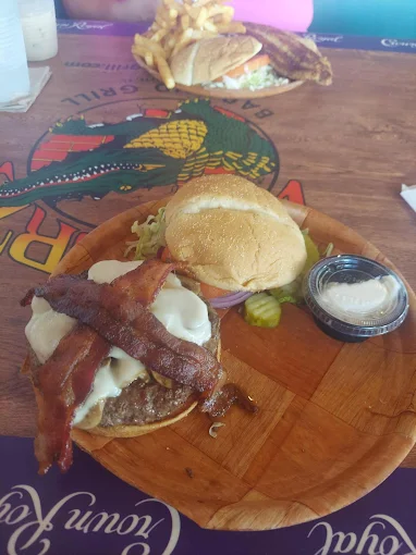 Bacon cheeseburger on a wooden board at Gatorz