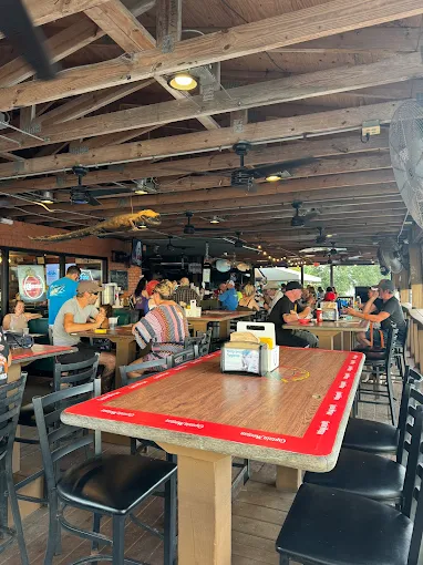 Open-air patio dining at Gatorz with high tops and ceiling fans