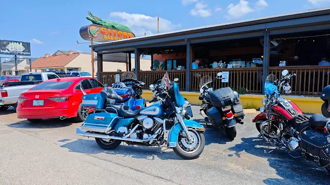 Motorcycles parked outside Gatorz under the green gator sign