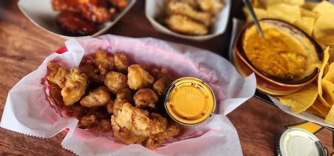 Basket of golden boneless wings with dipping sauce